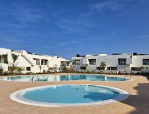 a large swimming pool in front of some apartments at - BM I Prime Apartment - in La Oliva
