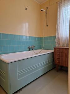 a bath tub in a bathroom with blue tiles at Arctic Cabin Lyngen in Svensby