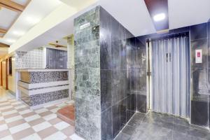 a bathroom with a shower with a glass door at OYO Sam Guest House in Chennai