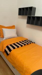an orange bed with a black and white blanket at Studio ensoleillé avec vue sur le lac in Lausanne