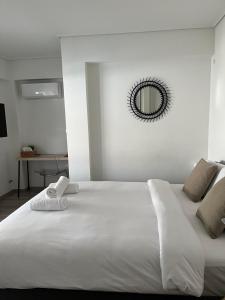 a large white bed with a mirror on the wall at Vamelon in Athens