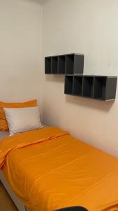 a bedroom with a bed with an orange blanket at Studio ensoleillé avec vue sur le lac in Lausanne
