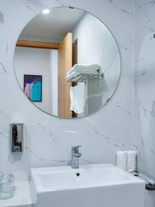 een witte badkamer met een spiegel en een wastafel bij Căn Hộ TMS View Biển Quy Nhơn in Quy Nhon
