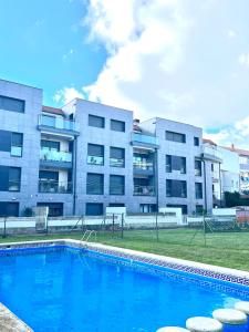 ein Gebäude mit einem Pool vor einem Gebäude in der Unterkunft Apartamento Carril in Vilagarcia de Arousa