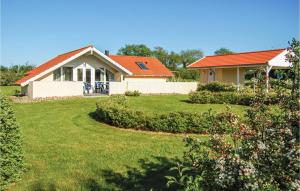 ノーポにあるBeautiful Home In Nordborg With 3 Bedrooms, Sauna And Wifiのオレンジの屋根と庭のある家