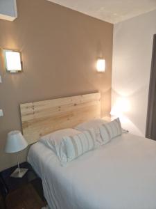 ein Schlafzimmer mit einem weißen Bett mit zwei Kissen in der Unterkunft Château d'Arance in Cette-Eygun
