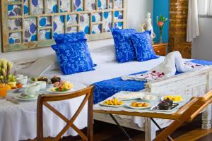 a bed with a table with plates of food on it at Pousada Solar dos Deuses in Salvador