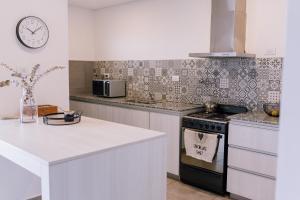 a kitchen with a stove and a clock on the wall at Duplex Alpha in Villa María