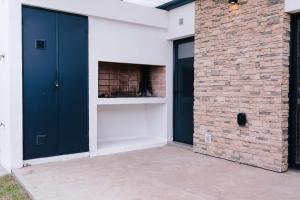 a building with two black doors and a brick wall at Duplex Alpha in Villa María