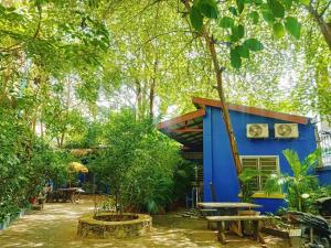 een blauw huis met een picknicktafel en bomen bij The Hideout in Kampot