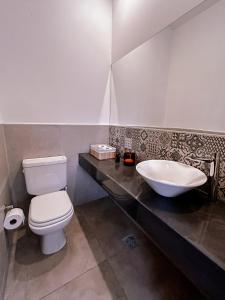 a bathroom with a white toilet and a sink at Duplex Alpha in Villa María +12 photos