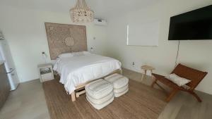 a bedroom with a bed and a chair and a tv at Seahorse Beach Bungalows in Fort Pierce