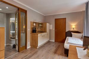 een hotelkamer met een bed en een keuken bij Mayer's Weinhotel in Zell an der Mosel