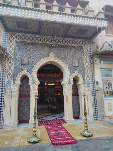 - une entrée à un bâtiment avec un tapis rouge au sol dans l'établissement PALAIS LARAICHI Riad la porte bleue suites, à Fès