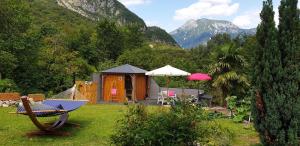 un complejo con hamaca y una cabaña con montañas en Casa Alpe-Adria, en Venzone