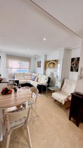 een woonkamer met witte meubels en een tafel bij San Pedro con ascensor y recogida in Santa Pola