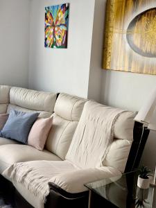 um sofá branco numa sala de estar com uma mesa de vidro em San Pedro con ascensor y recogida em Santa Pola