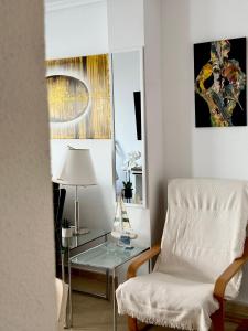 uma sala de estar com uma cadeira e uma mesa de vidro em San Pedro con ascensor y recogida em Santa Pola