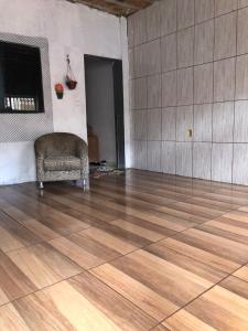 una stanza vuota con una sedia e un pavimento in legno di Canto da paz ad Angra dos Reis