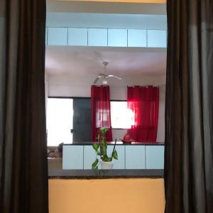 a kitchen with red curtains and a plant in a window at Canto da paz in Angra dos Reis