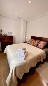 una camera da letto con un letto e asciugamani di San Pedro con ascensor y recogida a Santa Pola