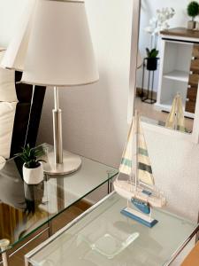 una mesa de cristal con una lámpara y un bote de juguete. en San Pedro con ascensor y recogida, en Santa Pola