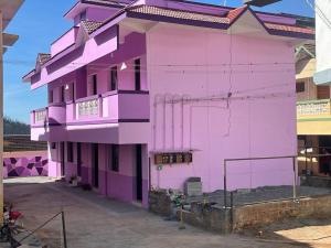 ein rosafarbenes Gebäude mit Avenue-Etage in der Unterkunft Hotel PNR'S Paradise in Udagamandalam