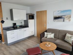 a living room with a couch and a kitchen at Ferienwohnung-2-in-der-Altstadt-Fam-Harder in Sassnitz