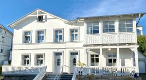 a white house with a white porch and stairs at Ferienwohnung-2-in-der-Altstadt-Fam-Harder in Sassnitz