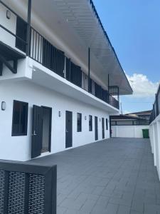 un edificio blanco con puertas negras y un patio en KRONOS APARTMENTS en Paramaribo