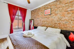 sypialnia z ceglaną ścianą i łóżkiem w obiekcie Cozy Montreal Suites in Prime Location w Montrealu