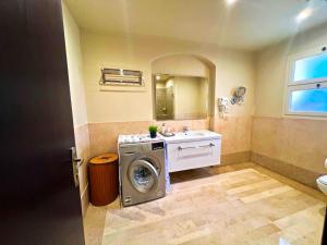 a bathroom with a washing machine and a sink at Azzura appartment sahl hashesh with private garden in Hurghada