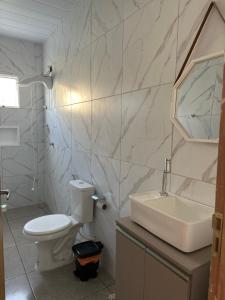 een witte badkamer met een wastafel en een toilet bij Bela Beach in São José da Coroa Grande +6 foto's