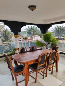 een houten tafel en stoelen in een kamer bij Belle Villa in Lomé