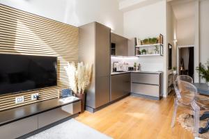 a living room with a large television and a table and chairs at Duomo 9 - Luxury Modern Loft in Milan