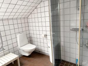 uma casa de banho branca com um WC e um chuveiro em Husrum på Österlen em Tomelilla