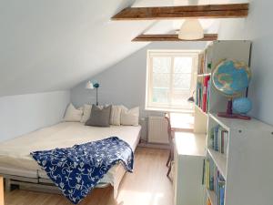 um pequeno quarto com uma cama e uma estante de livros em Husrum på Österlen em Tomelilla