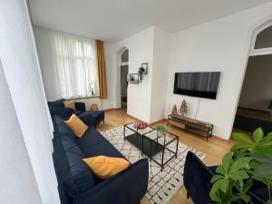 a living room with a blue couch and a tv at Ferienwohnung Marie in Bad Elster