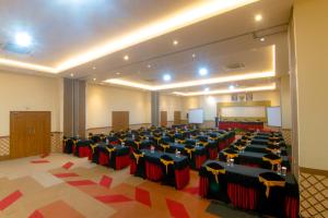 a large room with a bunch of tables and chairs at Front One Hotel Purwodadi in Purwodadi