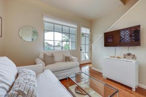 uma sala de estar com um sofá branco e uma mesa de vidro em Coastal Santa Barbara Townhome, Walk to Beach! em Santa Bárbara