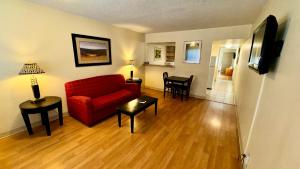 een woonkamer met een rode bank en een tafel bij Big Chile Inn & Suites in Las Cruces