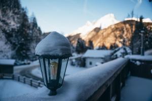 una luz de la calle cubierta de nieve en una valla en Alpe Chalets Goldener Hirsch en Scharnitz