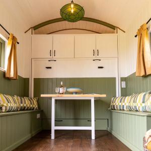 a small table in a room with a bench at Spring Grounds Farm Shepherd Huts 
