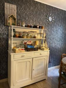 a white cabinet in a room with a shelf at Maison chaleureuse avec cheminée bord de rivière in Gérardmer