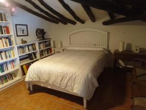 a bedroom with a white bed and book shelves at Casa Rural 643km in Villatuerta