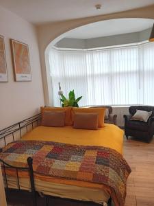 een slaapkamer met een bed met een kleurrijke quilt bij Flat 6 Corner House in Doncaster