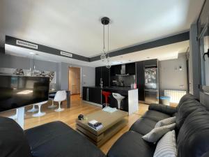 a living room with a couch and a tv at Precioso apartamento con piscina y parking in Tossa de Mar