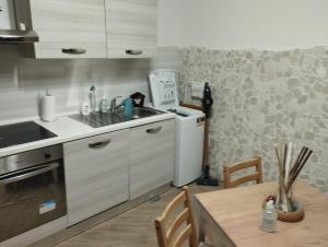 uma cozinha com um lavatório, um frigorífico e uma mesa em Il basso di Gilda em Nápoles