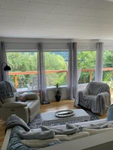 a living room with a couch and a large window at Sweet Creek Retreat in Nelson