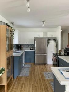 a kitchen with blue cabinets and a stainless steel refrigerator at Sweet Creek Retreat in Nelson